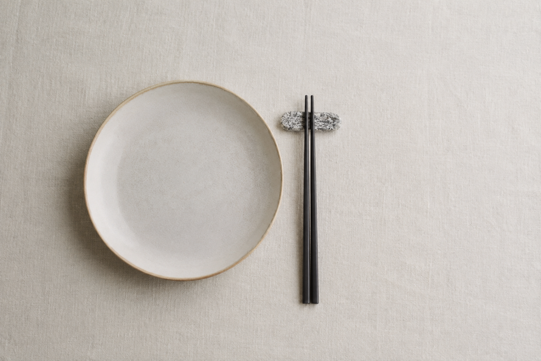 Small Makabe stone cutlery rest in an open, uncluttered place setting beside a plate.