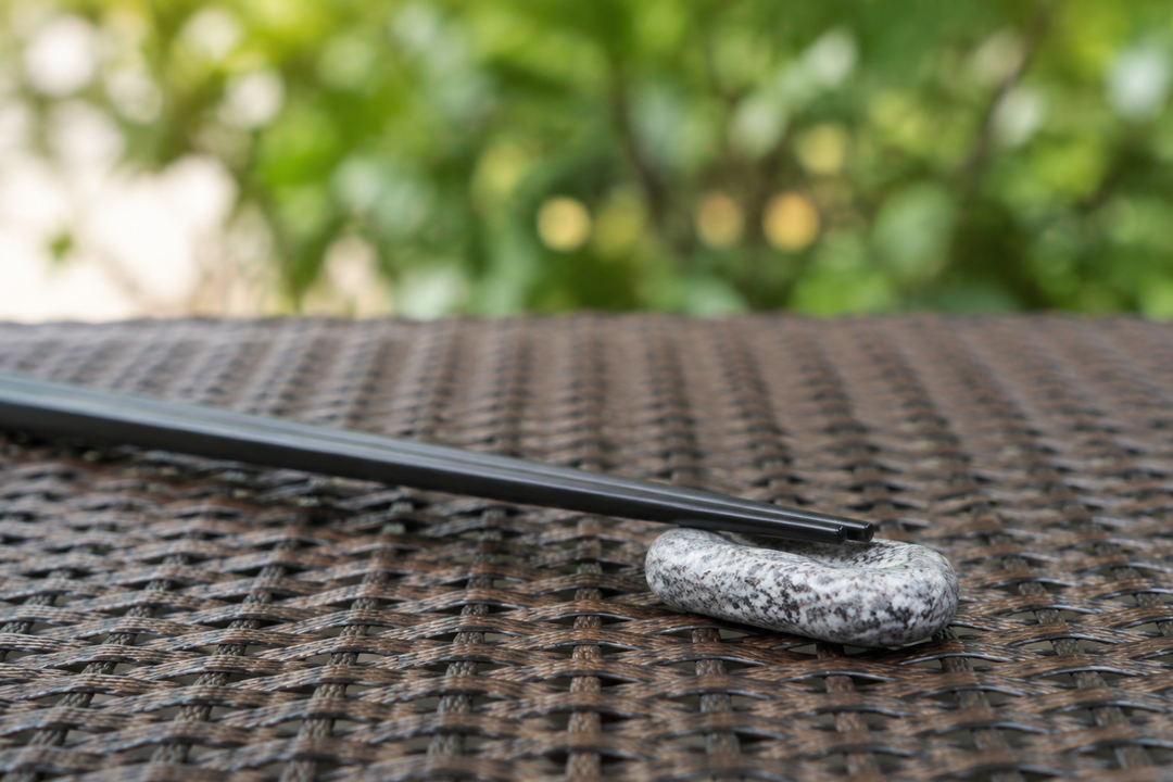 Makabe stone cutlery rest with black chopsticks on a stable outdoor table in daylight.