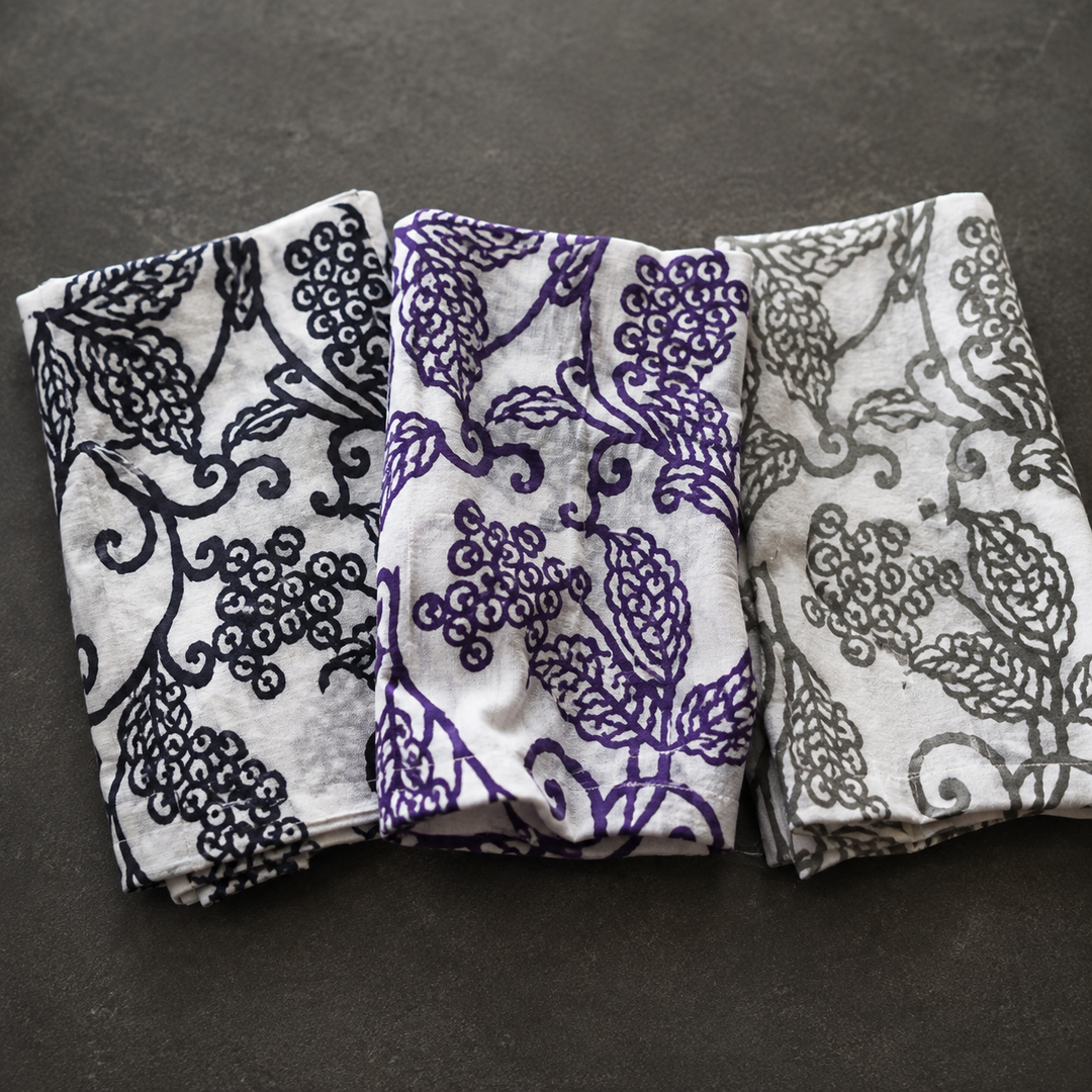 Three arabesque-pattern tenugui arranged in relaxed compact folds that reveal different visible portions of the design.