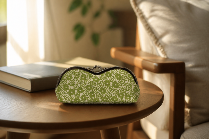 Yellow-green Tokyo Some-Komon eyeglass case on a side table beside an indoor reading chair.