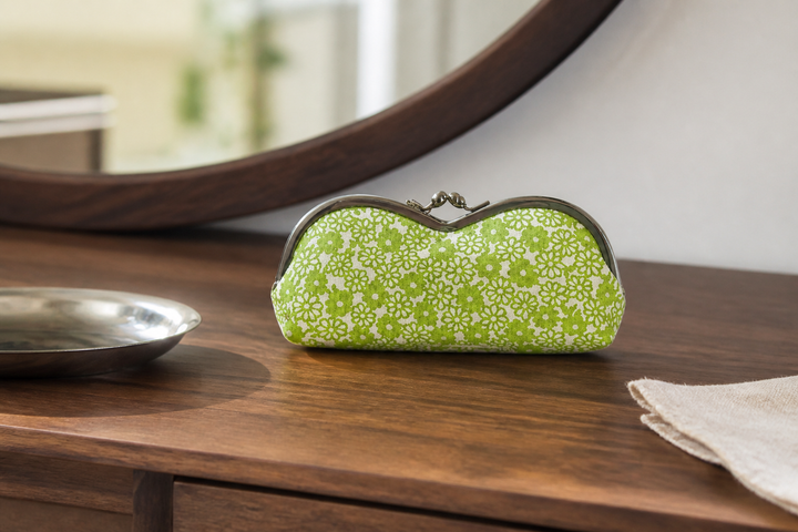 Yellow-green Tokyo Some-Komon eyeglass case arranged on an indoor dressing table.