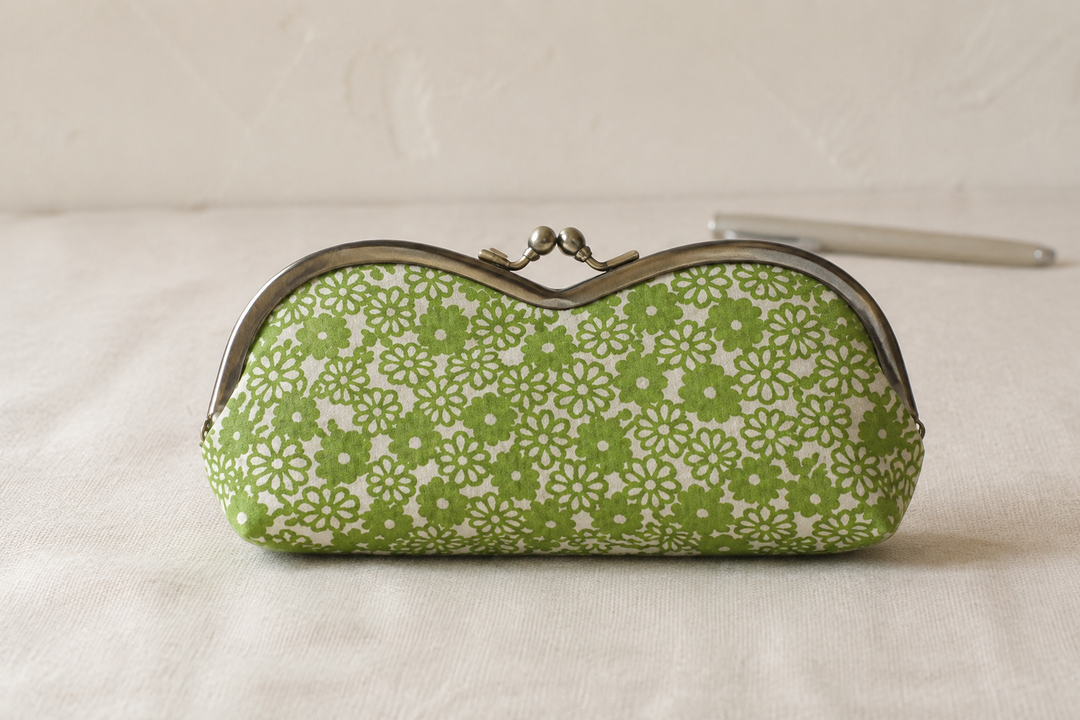 Close view of the small white floral pattern on a yellow-green Tokyo Some-Komon eyeglass case in soft daylight.