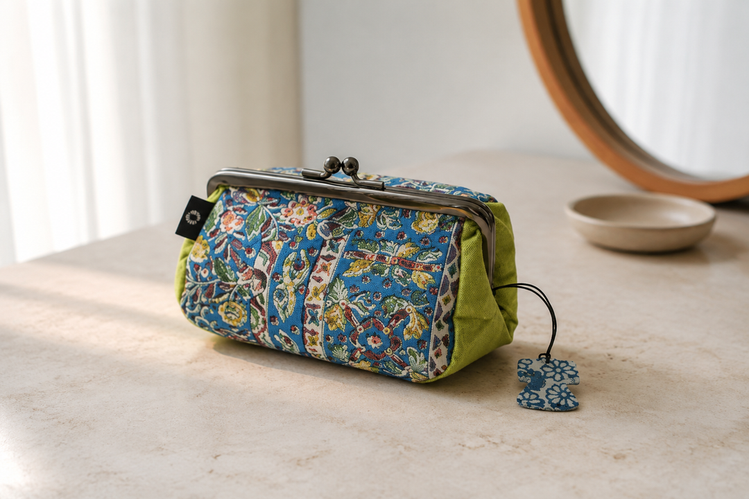 Turquoise and yellow-green Edo Sarasa silk pouch visible inside an open handbag in soft daylight.