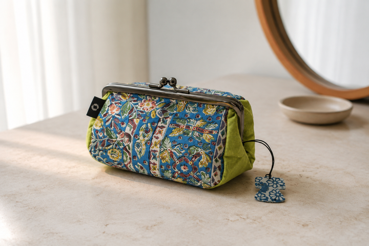 Turquoise and yellow-green Edo Sarasa silk pouch visible inside an open handbag in soft daylight.