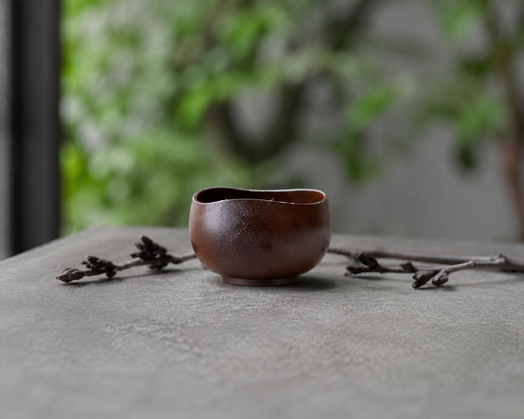 Bud: Lilac lacquerware vessel on a stable shaded terrace table away from direct sun.