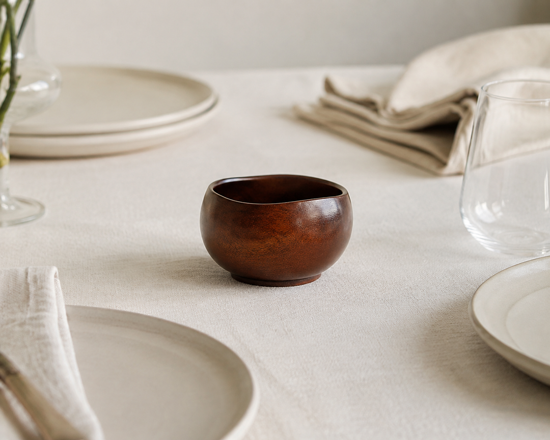 Bud: Mimosa lacquer vessel displayed empty on a composed dining table between meals.