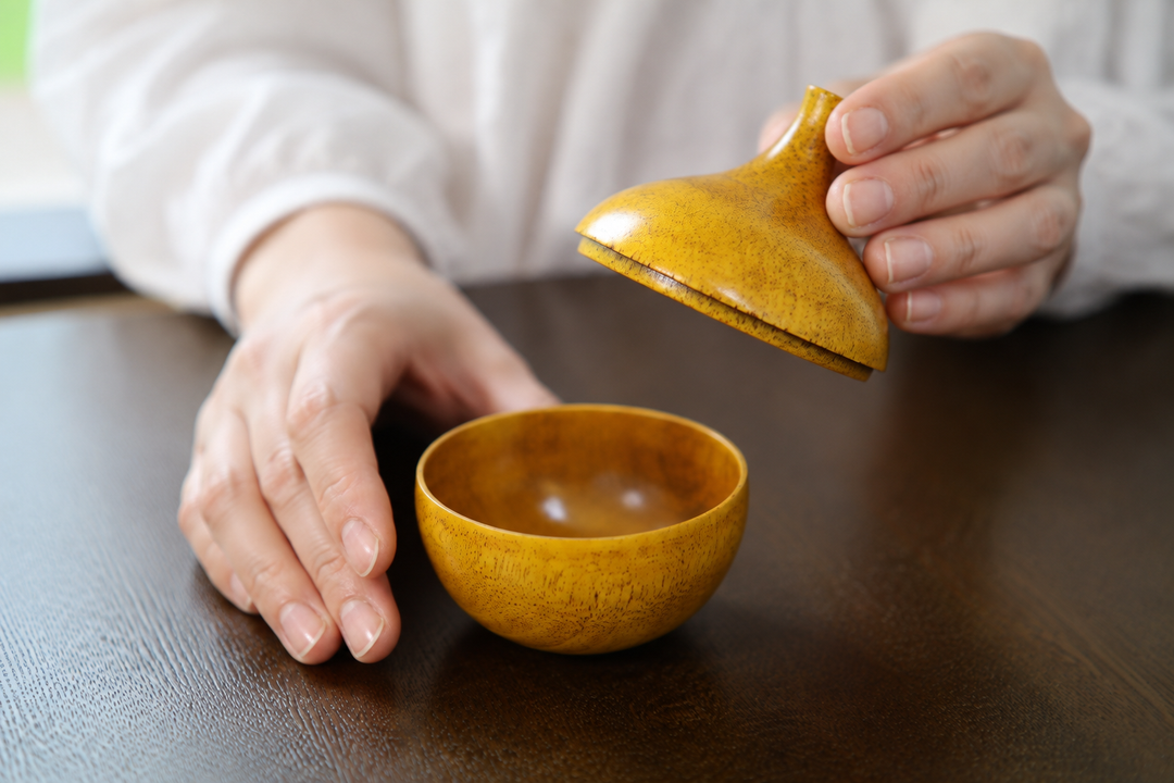 Closed Bulb: Mimosa lacquerware displayed on a calm entry console beside restrained natural materials.