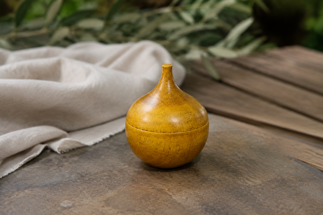 Closed Bulb: Mimosa on a dry shaded outdoor table with soft greenery in the background.