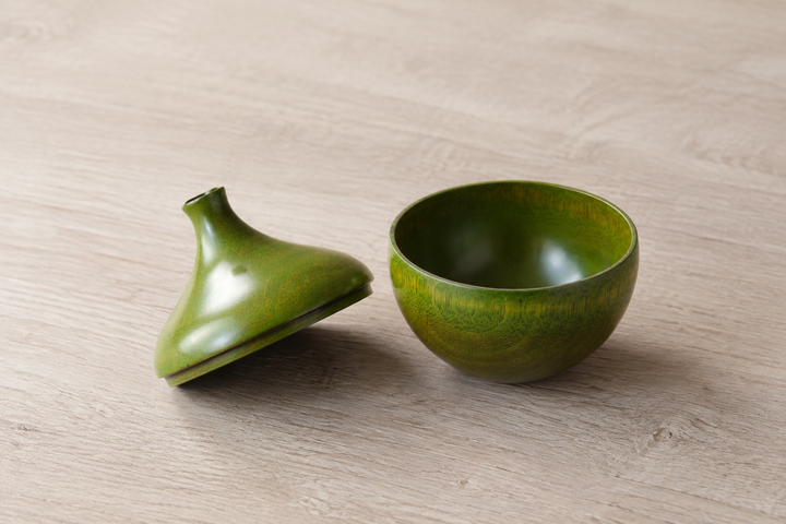 The olive lacquer lid placed beside its matching bowl, showing the darker interior and precise two-part geometry.
