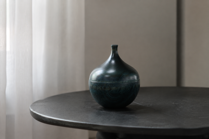 Closed blue-green Bulb: Hyacinth lacquerware catching subtle highlights beside a sheer-curtained window.
