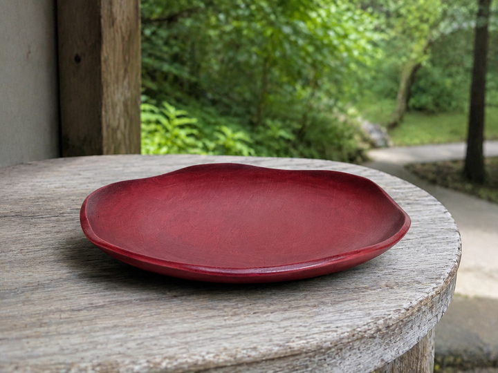RIN 5.0 Berry on a dry shaded terrace side table with soft greenery beyond.
