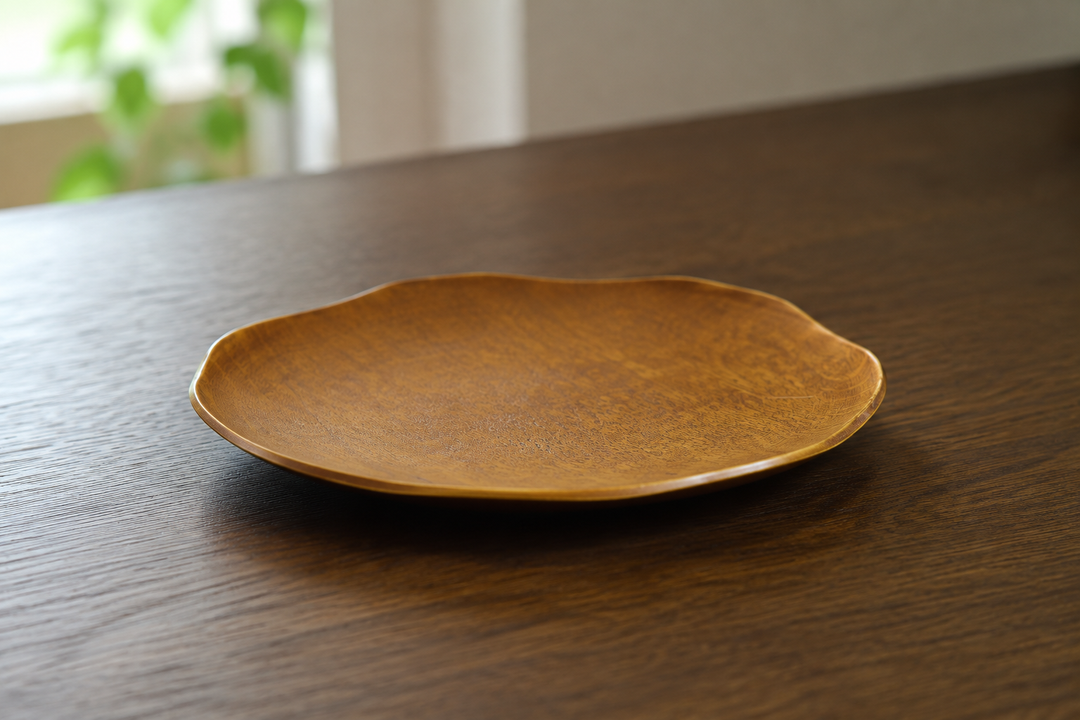 Low side profile and softly irregular rim of the empty Mimosa RIN 7.0 lacquerware plate on a stable table.