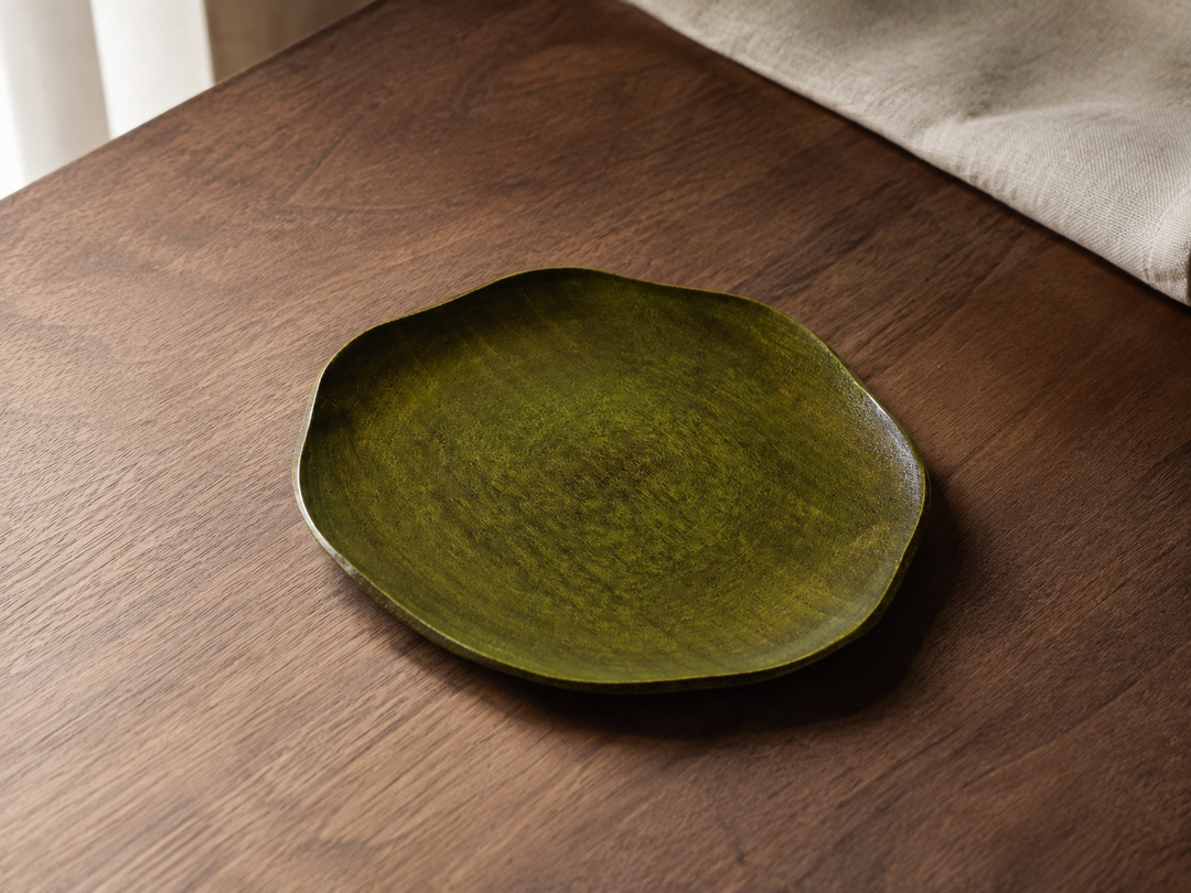 Empty RIN 7.0 Olive centered on a small restrained dining table with its full low outline visible.