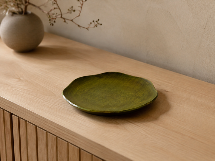 Empty RIN 7.0 Olive displayed indoors on a sideboard with its softly irregular outline visible from above.
