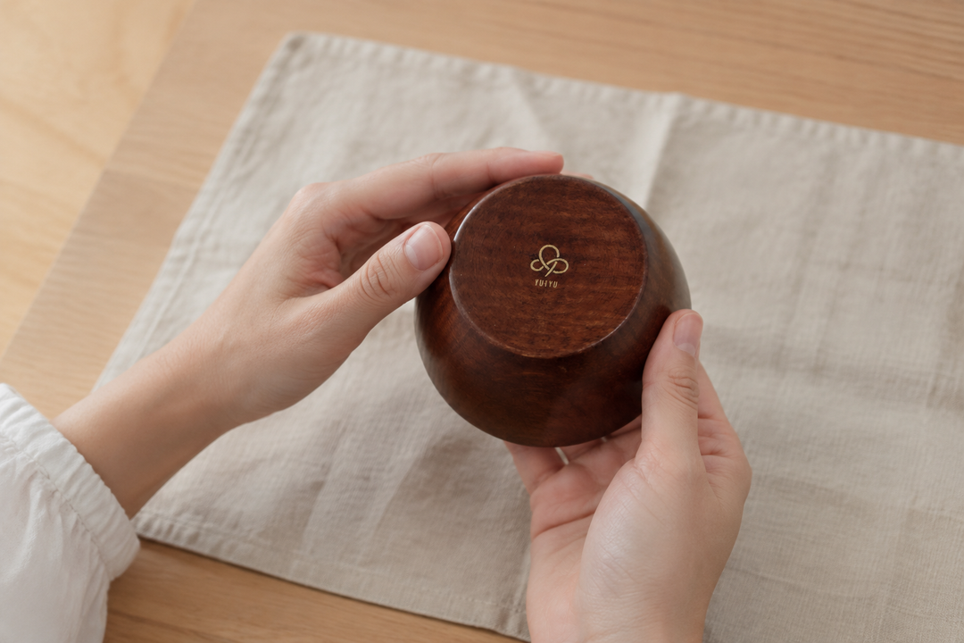 Adult hands briefly turning the clean empty RIN Bowl S Lilac to reveal its photographed YUIYU base mark.