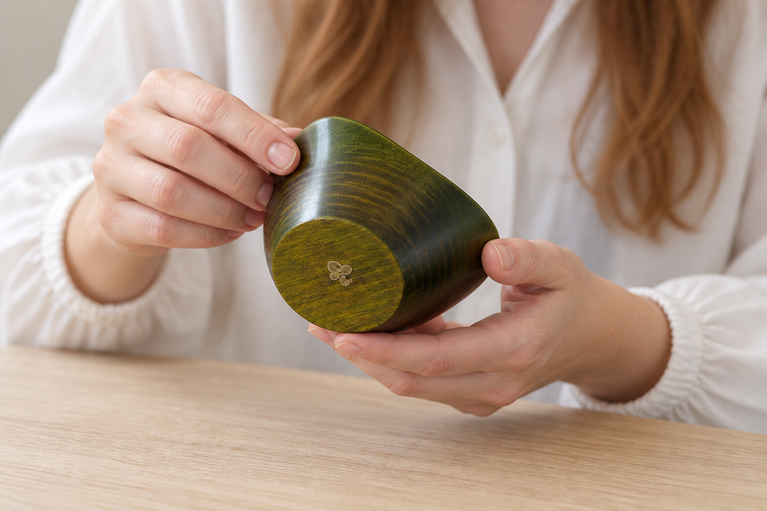 Adult hands gently turning the empty RIN Bowl S Olive to glimpse the small supplied mark on its base.