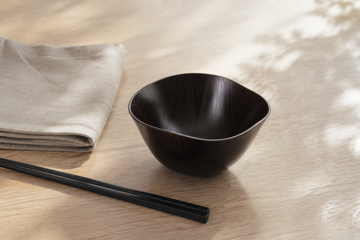 Empty RIN Bowl M Lilac beside chopsticks and a folded linen napkin in a quiet place setting.