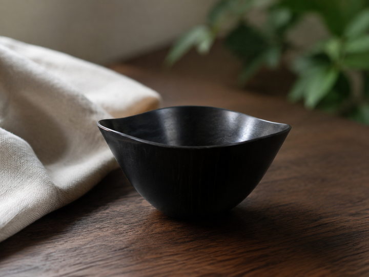 Empty RIN Bowl M Sesame on pale linen and dark wood, showing its softly irregular rim and compact silhouette.