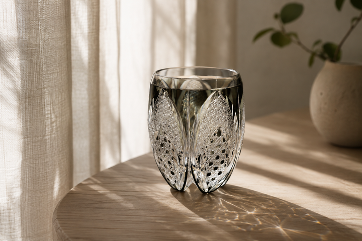 Korohana Blue Ink Edo Kiriko vessel catching soft window light on a pale wood table.