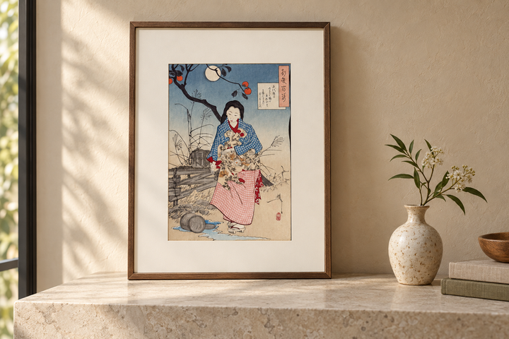 The framed Yoshitoshi print of Chiyono displayed on a pale stone console beside a small vase and books.
