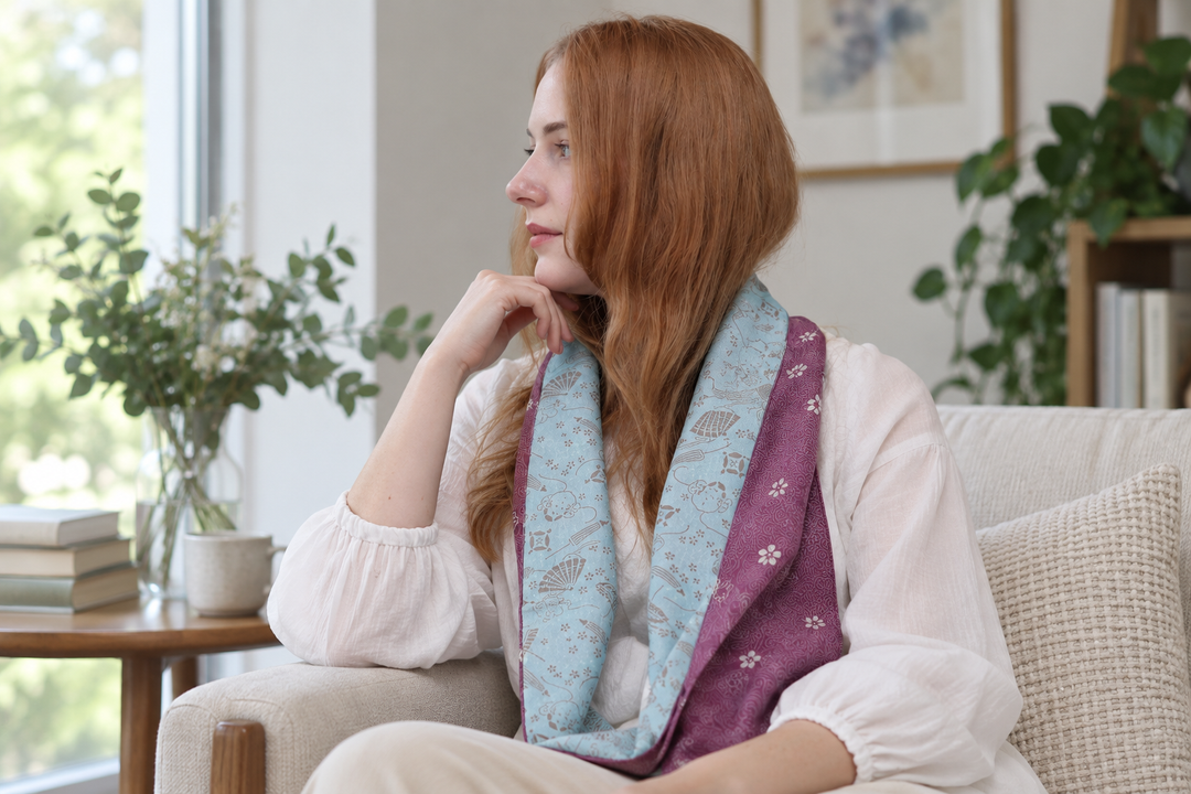 An adult wearer drapes the pale blue and purple faces of the double-sided silk stole together over a neutral outfit.