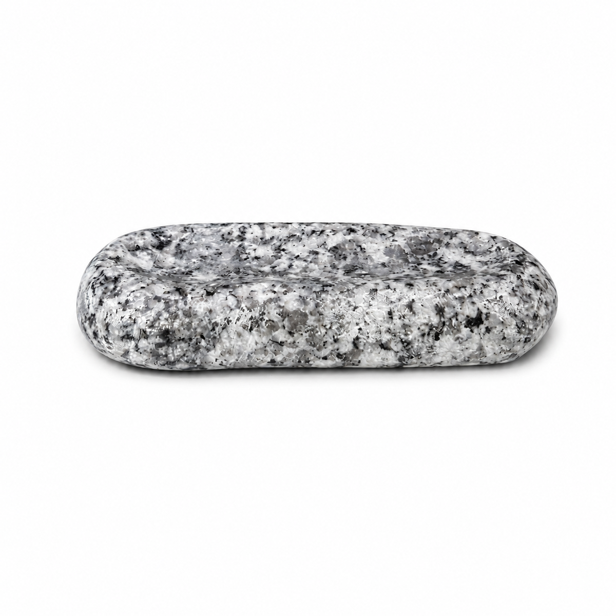 Makabe Stone Cutlery Rest on a pure white background, showing its rounded granite form and shallow groove.