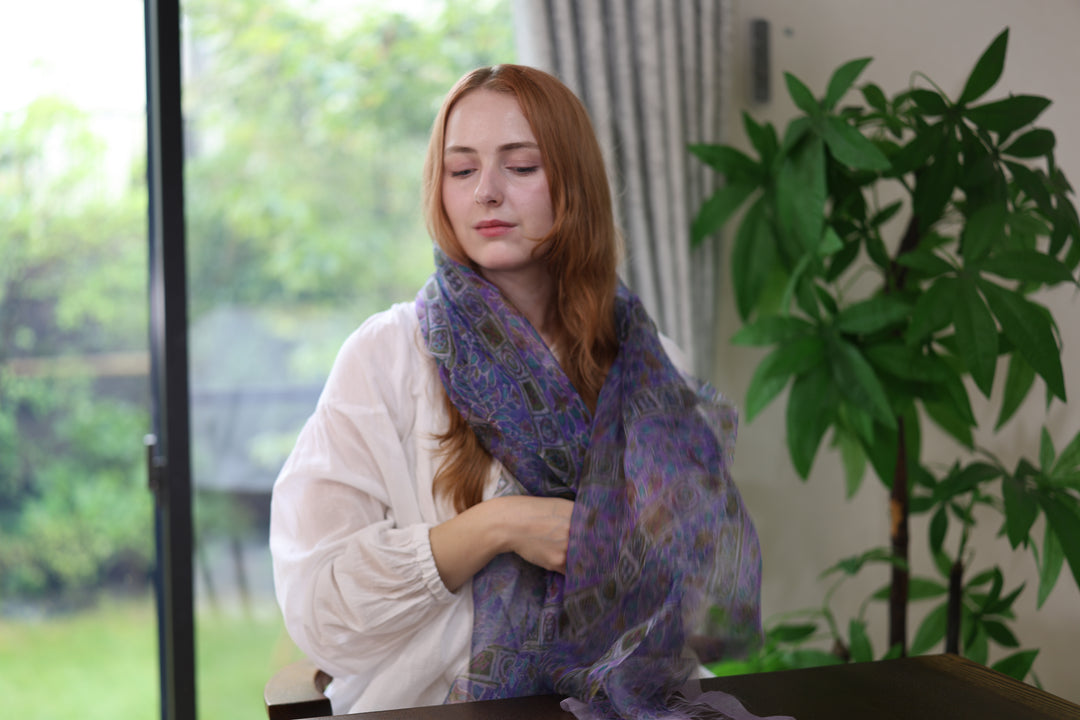 A seated wearer draping the purple Edo Sarasa silk stole over a white blouse.