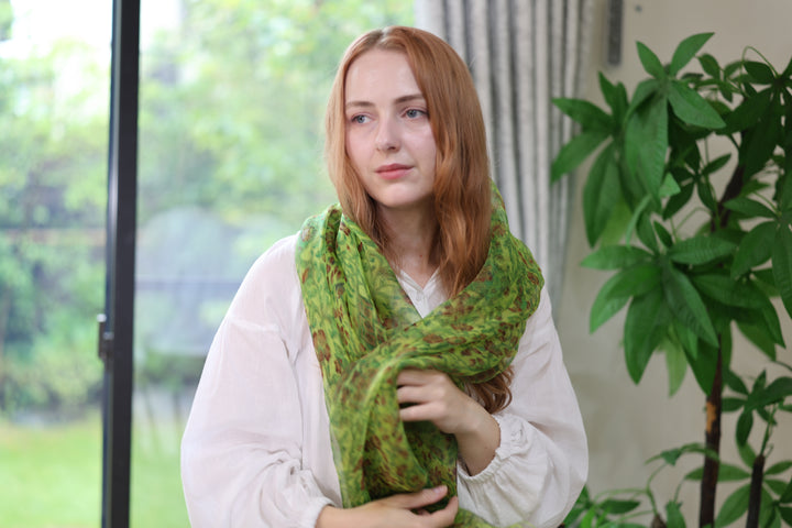 A woman wearing the green Edo Sarasa silk stole near a window