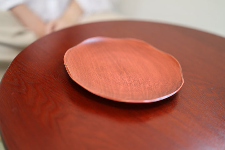 Berry-red RIN lacquerware plate resting on a warm red table