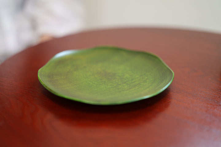RIN 7.0 Olive lacquerware resting empty on a red table in an interior.