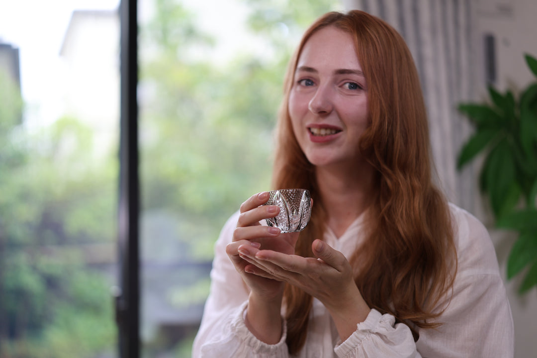 Adult model holding the GENEN Blue Ink cup near a bright window.