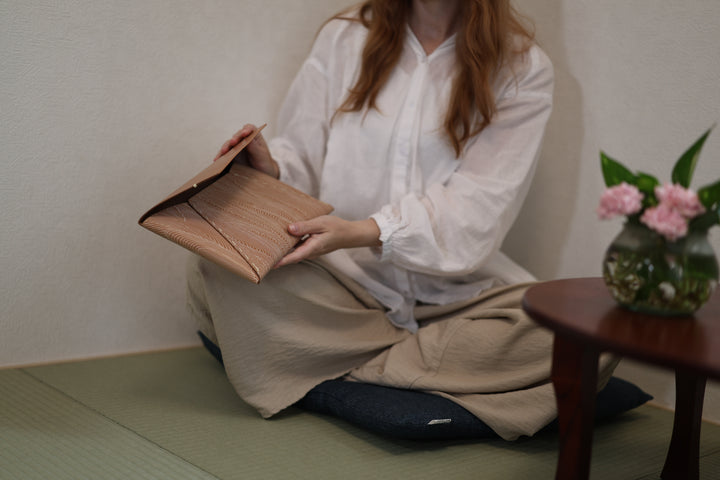 The natural leather clutch opened while seated in a tatami room.
