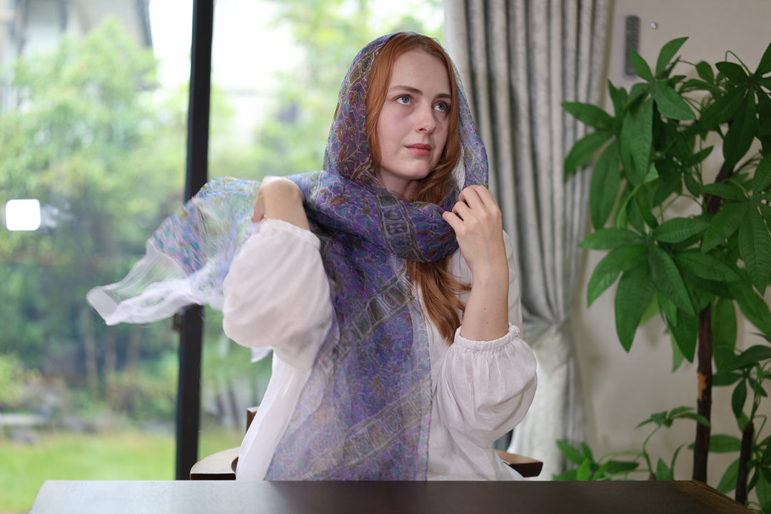 A wearer lifting one end of the purple Edo Sarasa stole while wrapping it at the neck.
