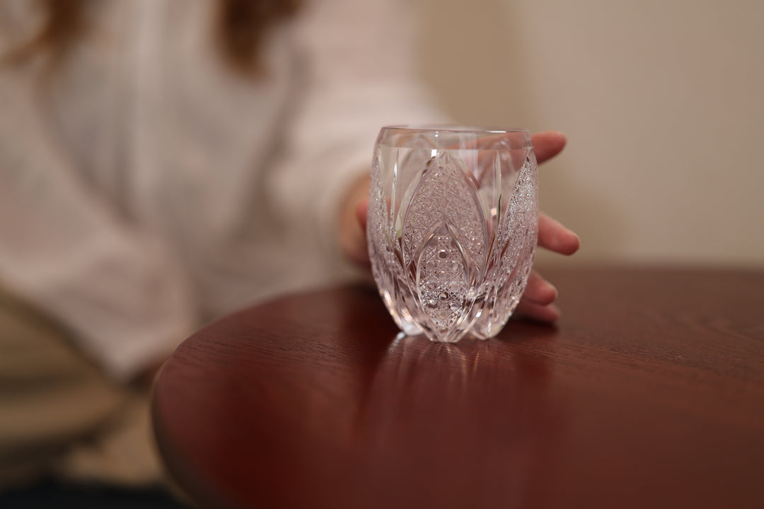 SHIROHANA: Clear standing on a round wooden table beside a seated adult model.