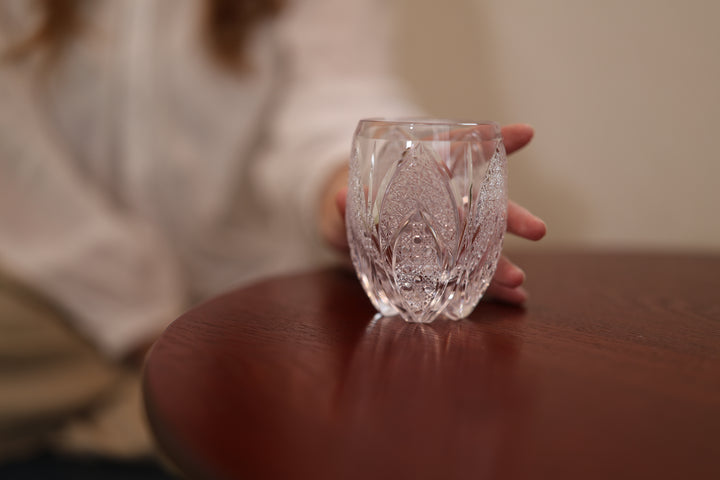 SHIROHANA: Clear standing on a round wooden table beside a seated adult model.