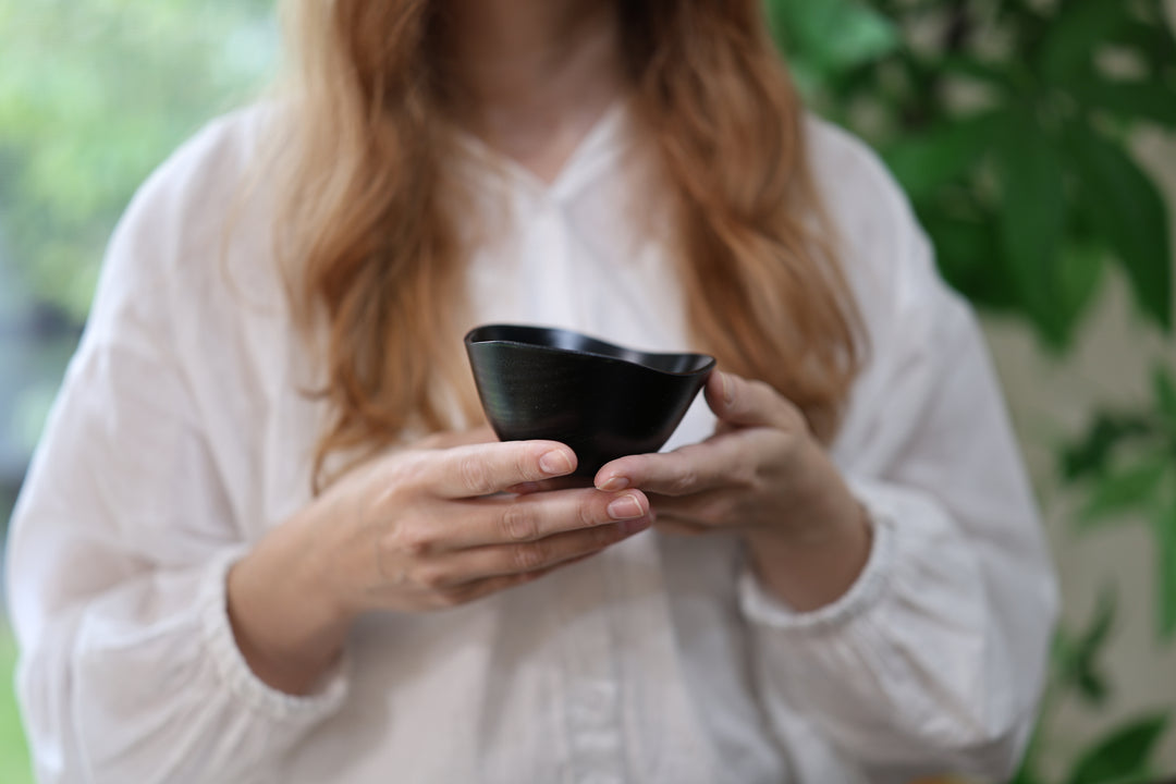 Close view of an adult model holding the RIN Bowl S Hyacinth in both hands.