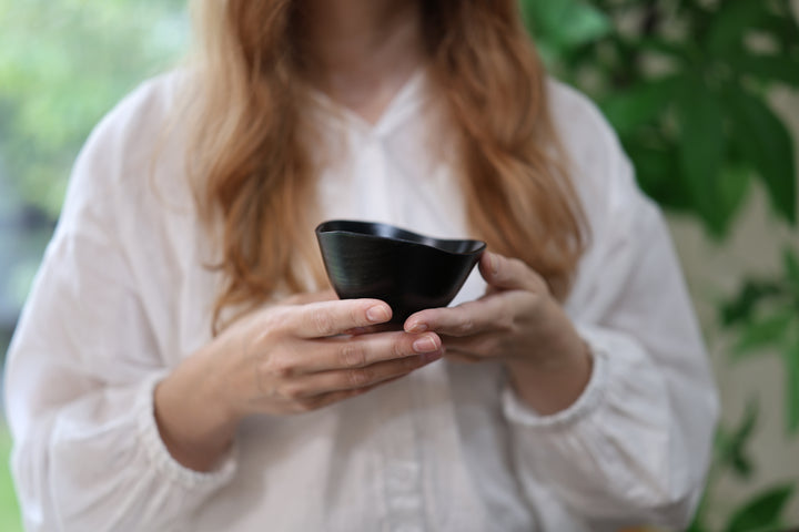 Close view of an adult model holding the RIN Bowl S Hyacinth in both hands.