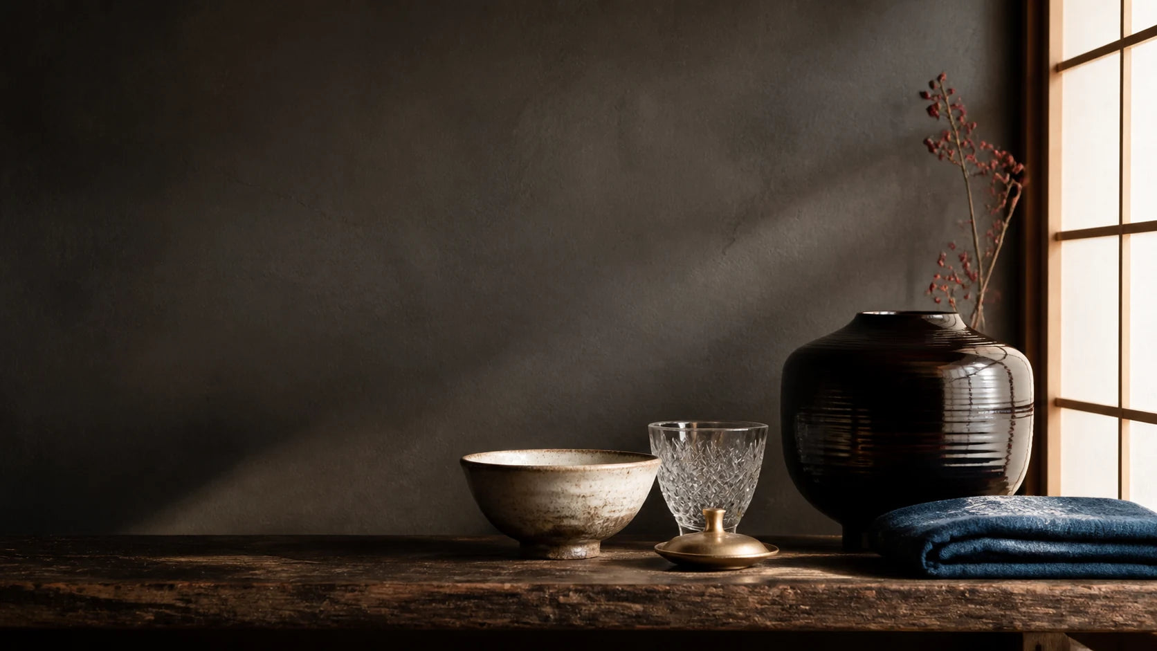 Editorial still life of ceramic, lacquer, glass, metal and indigo textile forms in a contemporary Japanese interior